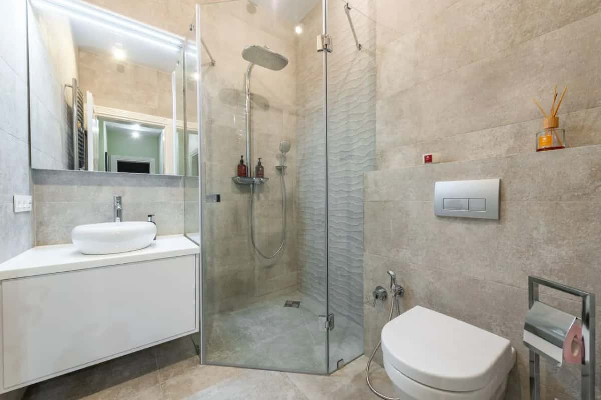 Baño doméstico con lavabo y zona de ducha, escenario habitual de una inundación por avería