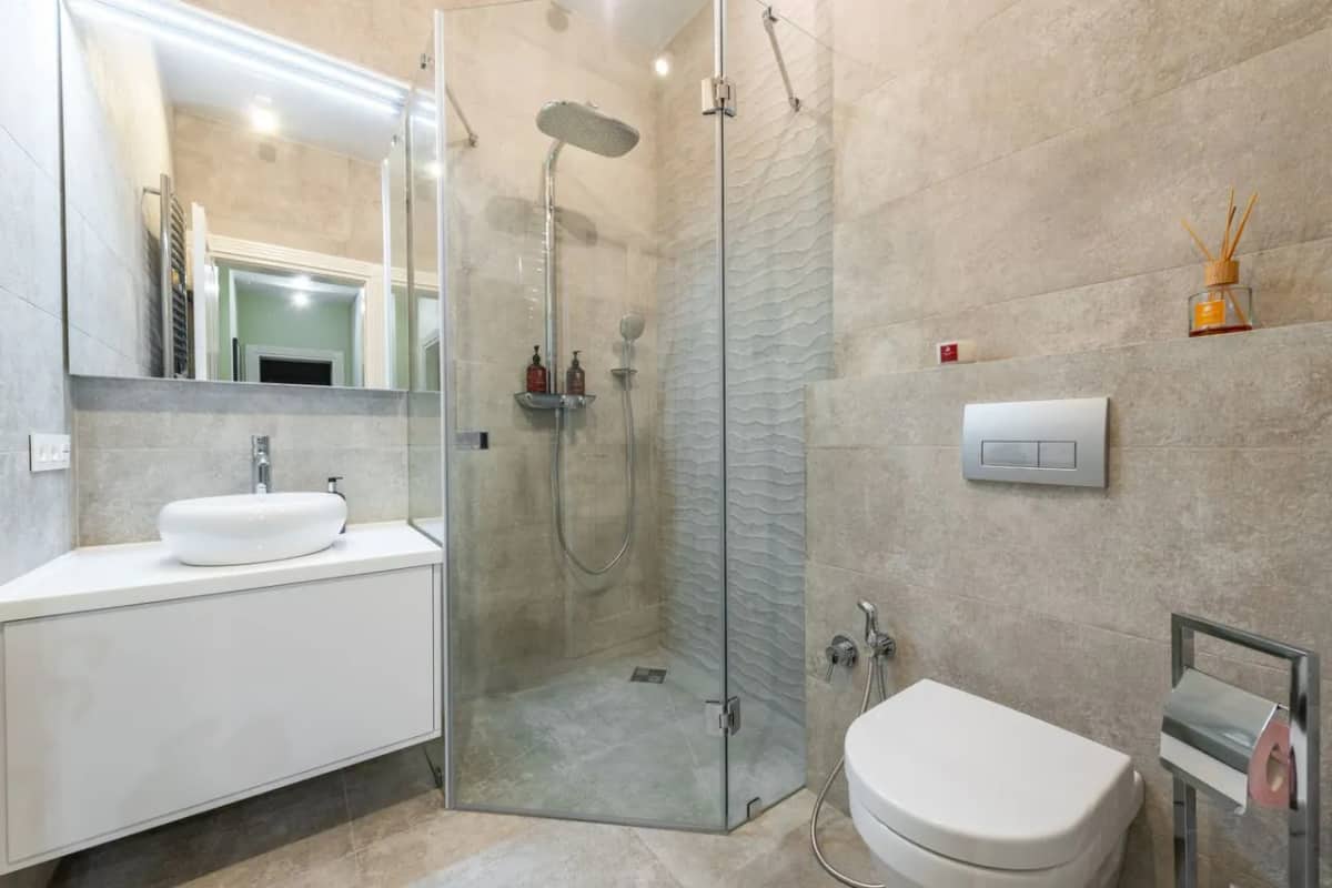 Baño doméstico con lavabo y zona de ducha, escenario habitual de una inundación por avería