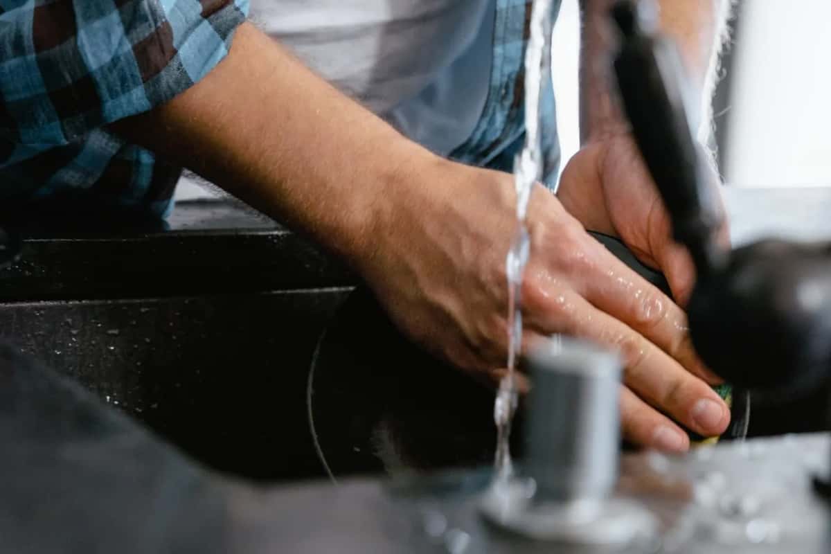 Desagüe de fregadero con agua corriendo, donde el sifón hace de cierre hidráulico contra los olores